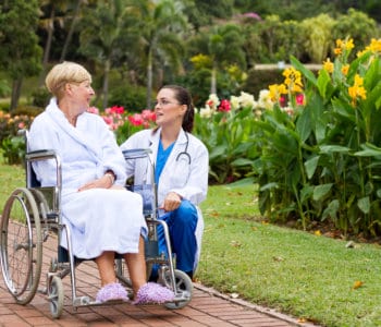 senior woman in wheelchair with her nurse